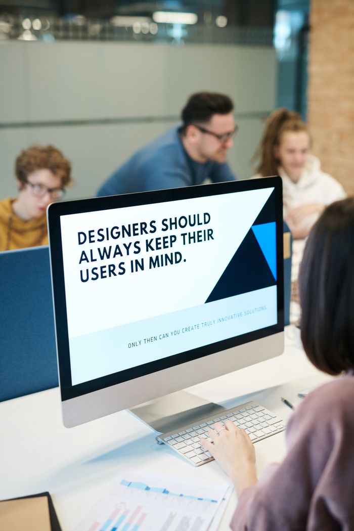 mission-img Group of designers collaborating in modern office space with computer.
